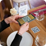 mujer escaneando qr en una mesa con platos